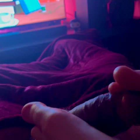 She uses her toes to play with my cock while she watches cartoons - free porn video